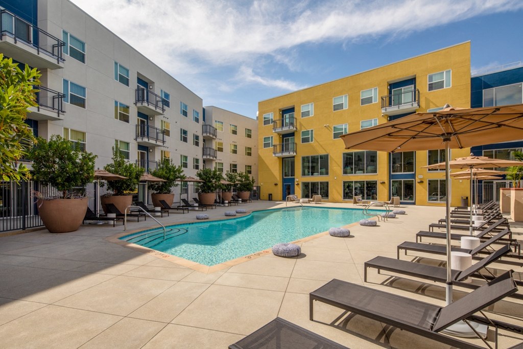 sparkling pool with sun lounger chairs at Aston at Gateway apartments in El Monte, California