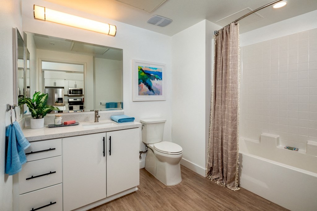 apartment bathroom with vanity cabinets and bathtub at Aston at Gateway apartments in El Monte, California
