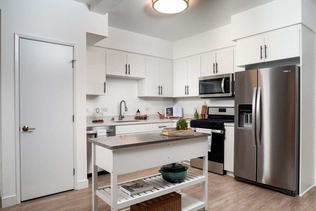 apartment kitchen with stainless steel appliances and kitchen island at Aston at Gateway apartments in El Monte, California