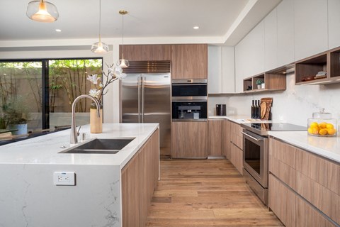 a large kitchen with wooden cabinets and marble counter tops