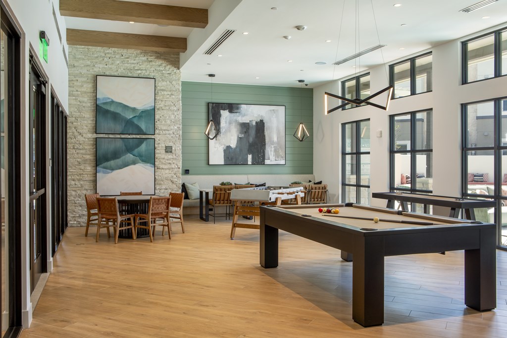 A room with a pool table and a dining table.