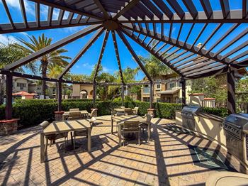 A patio with a table and chairs under a roof.
