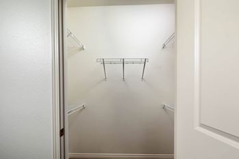 A white closet with a metal rack and shelves.
