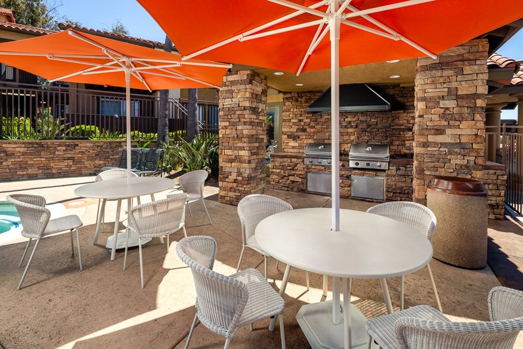 a patio with tables and chairs and umbrellas