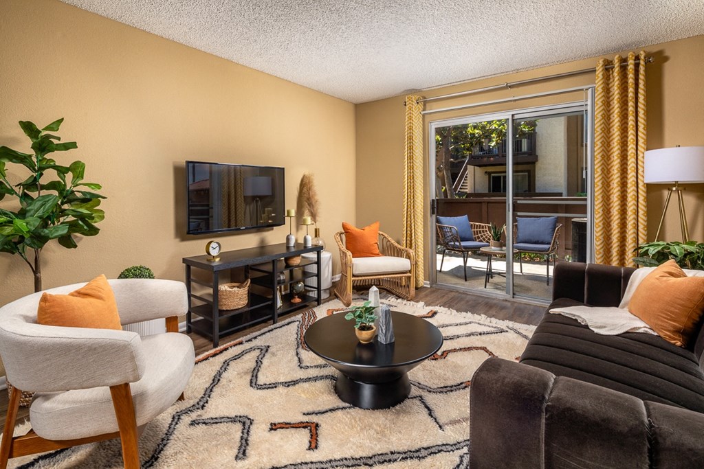 a living room with a couch and chairs and a tv