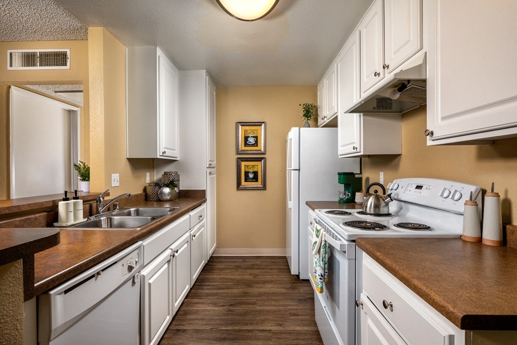 a kitchen with white appliances and counters and white cabinets
