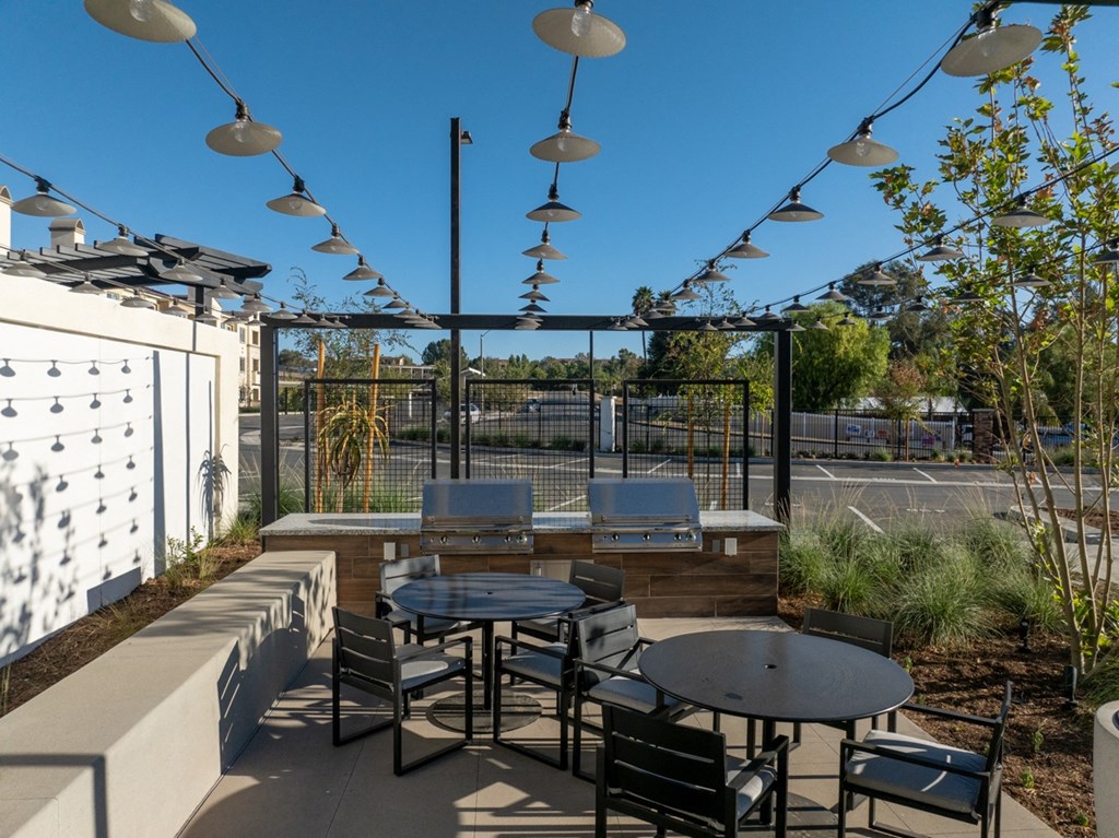 a patio with tables and chairs and a fence