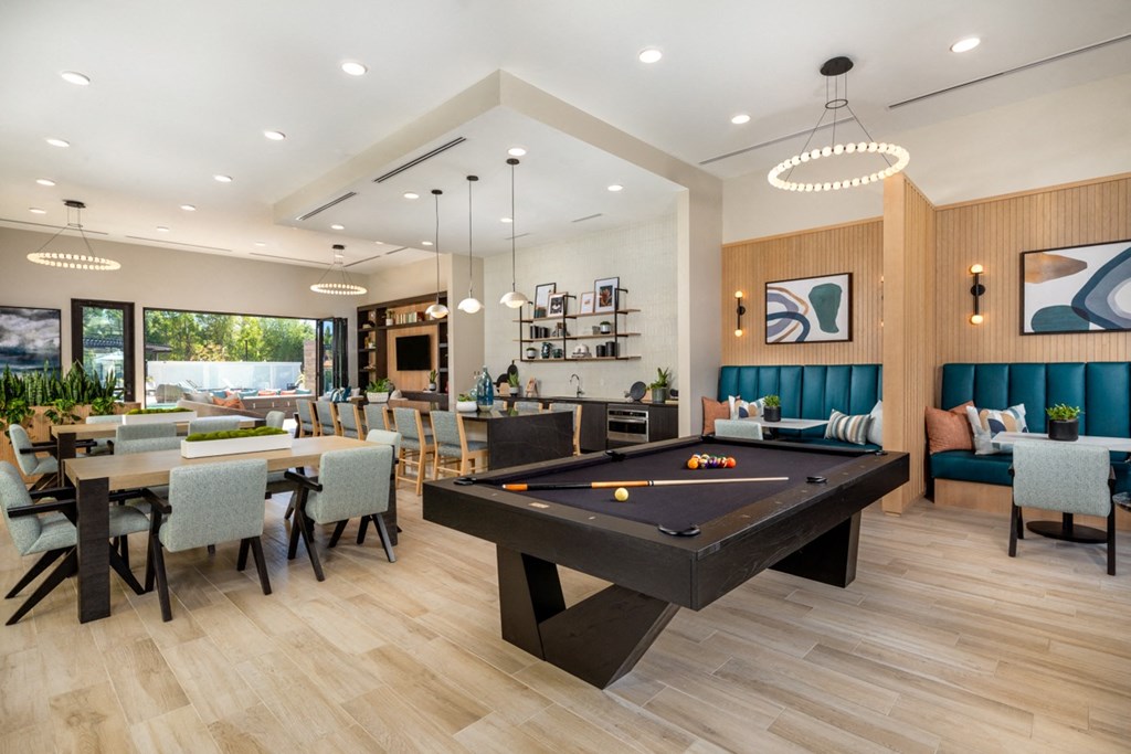 a clubhouse with a pool table and a dining room with tables and chairs