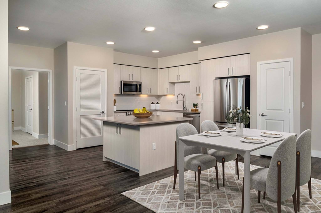 A modern kitchen with a dining table set for four.