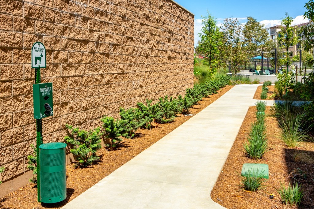 a sidewalk with a parking meter next to a wall