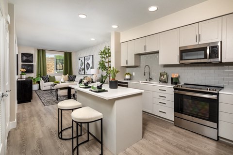 a kitchen and living room with white cabinets and a counter