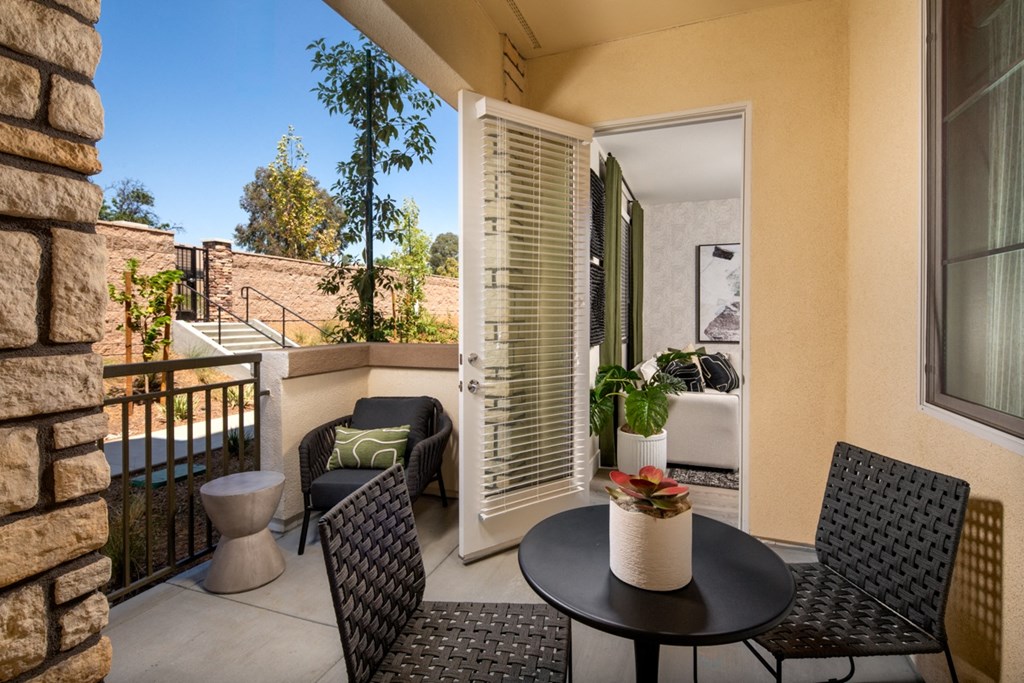 a 1-bedroom patio with chairs and a table on a balcony