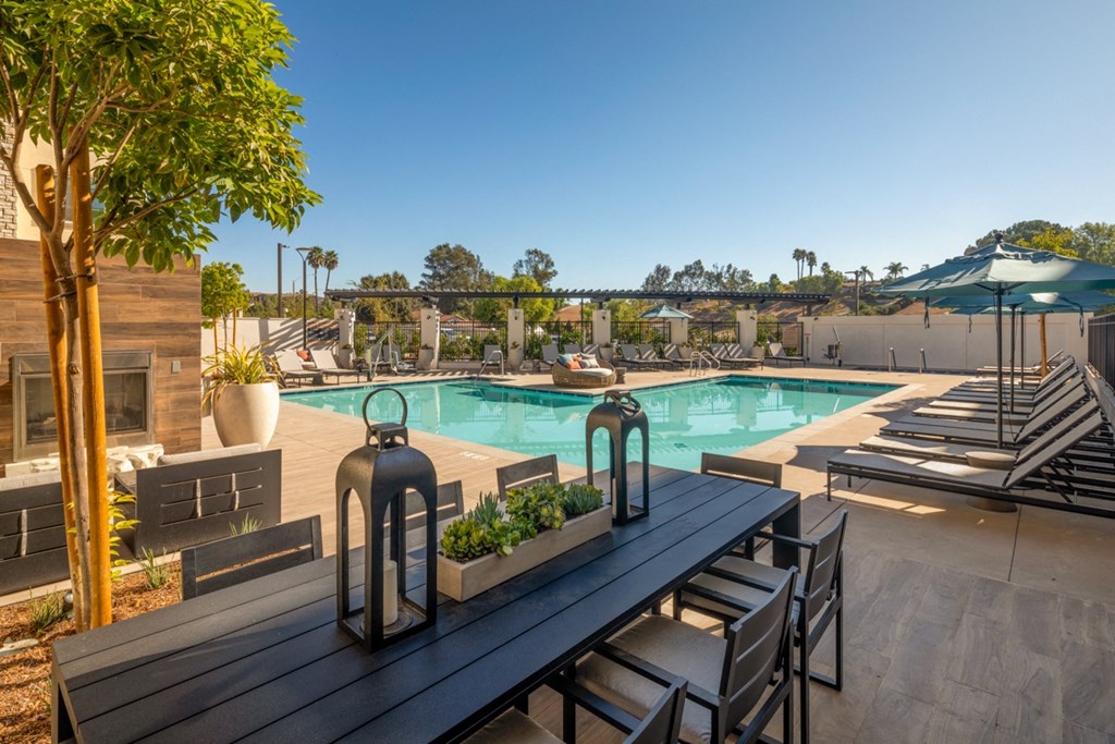 a swimming pool with tables and chairs and umbrellas