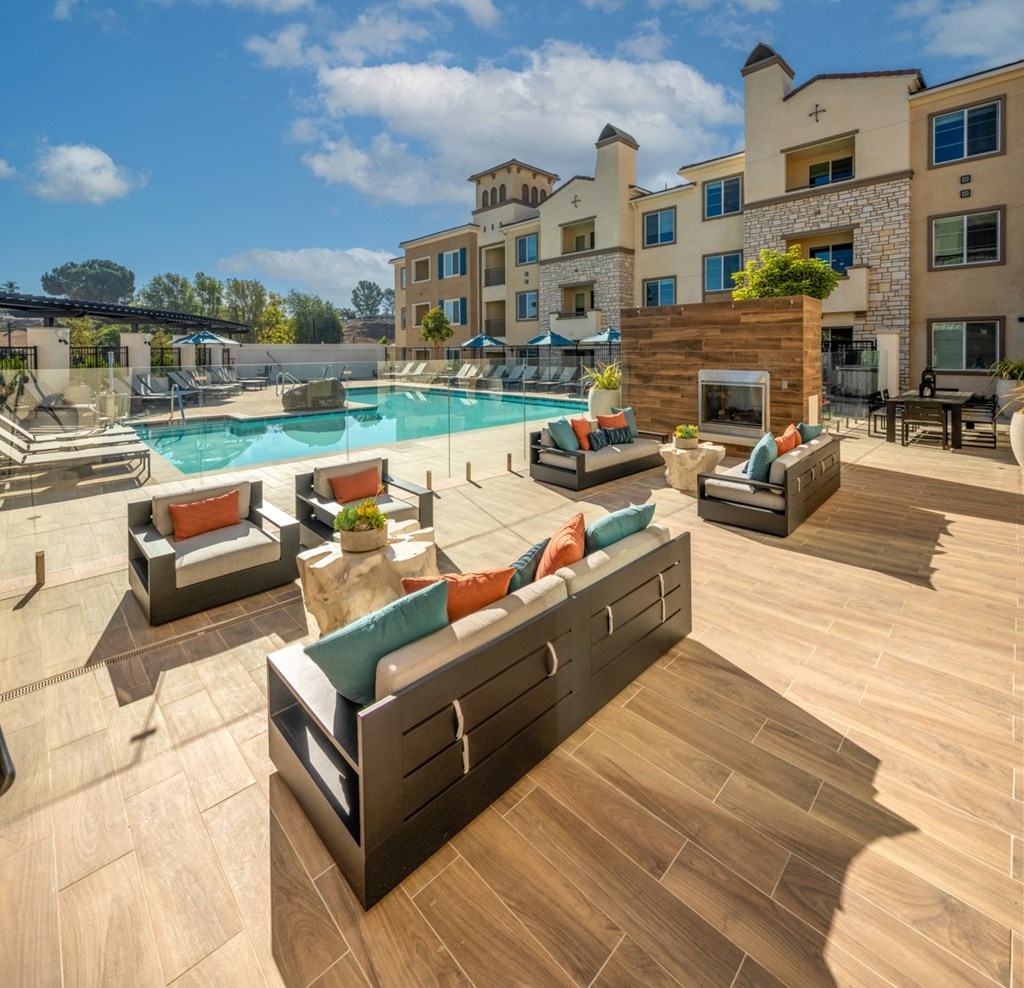 a pool with lounge furniture and a building in the background