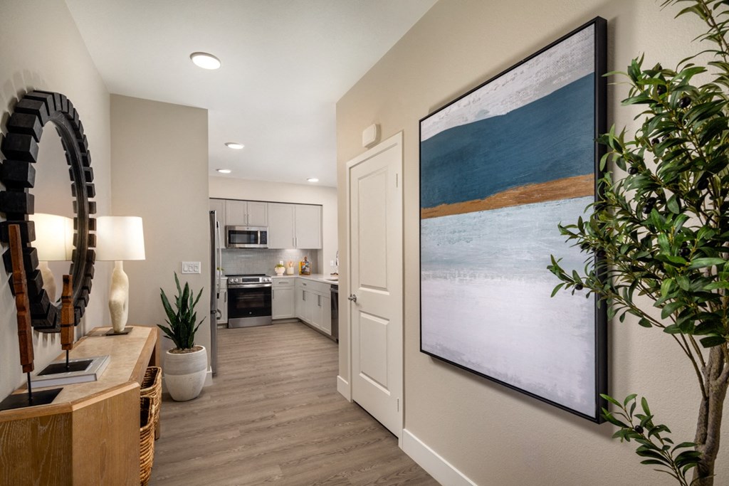 an open kitchen and living room with a large painting on the wall