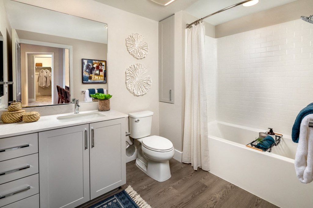 a bathroom with a toilet and a tub and a sink