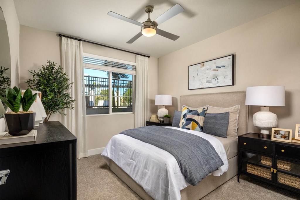 an empty bedroom with a bed and a ceiling fan