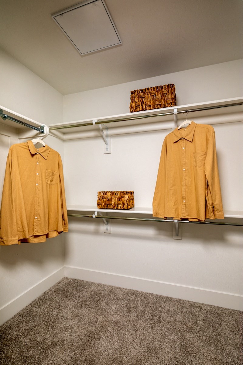 two shirts hanging on a rack in a closet