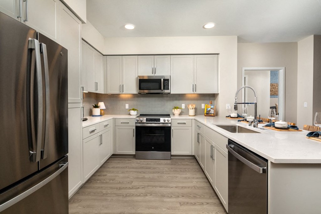 a kitchen with white cabinets and stainless steel appliances