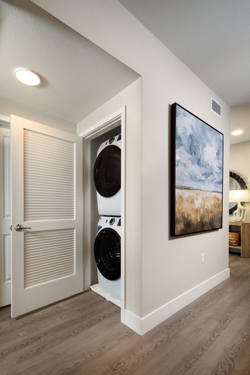 an empty hallway with a laundry room with a washer and dryer