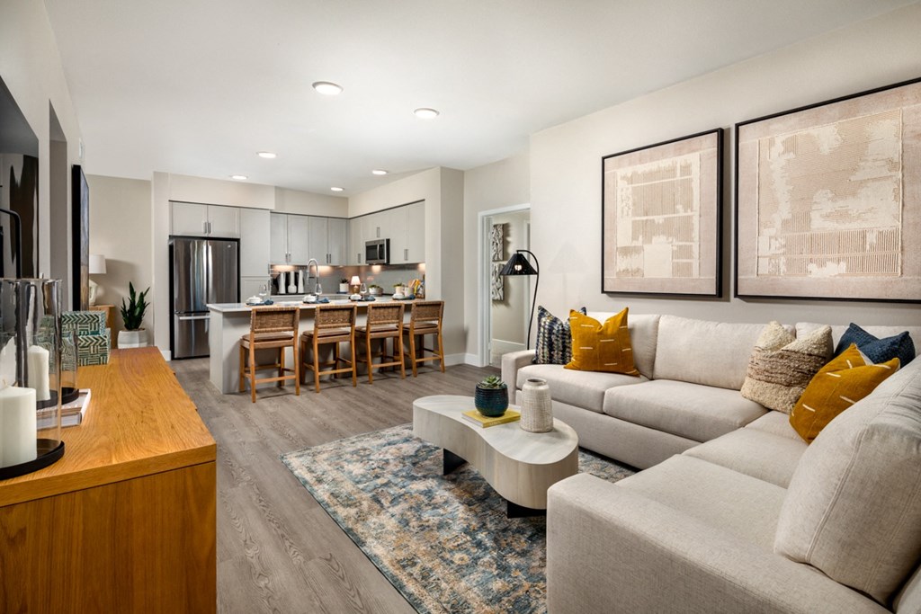 a living room with a couch and a table in front of a kitchen