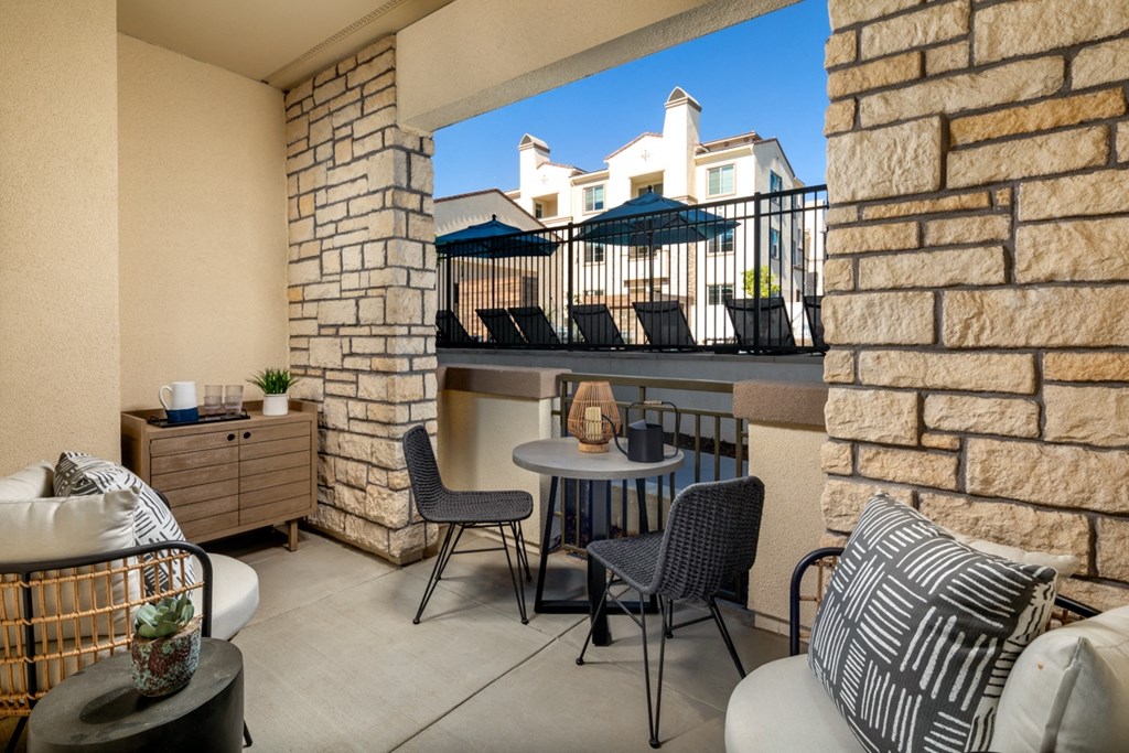 a patio with chairs and a table on a balcony