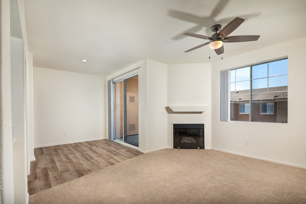 Living room with a fireplace and a ceiling fan at Casoleil, 92154