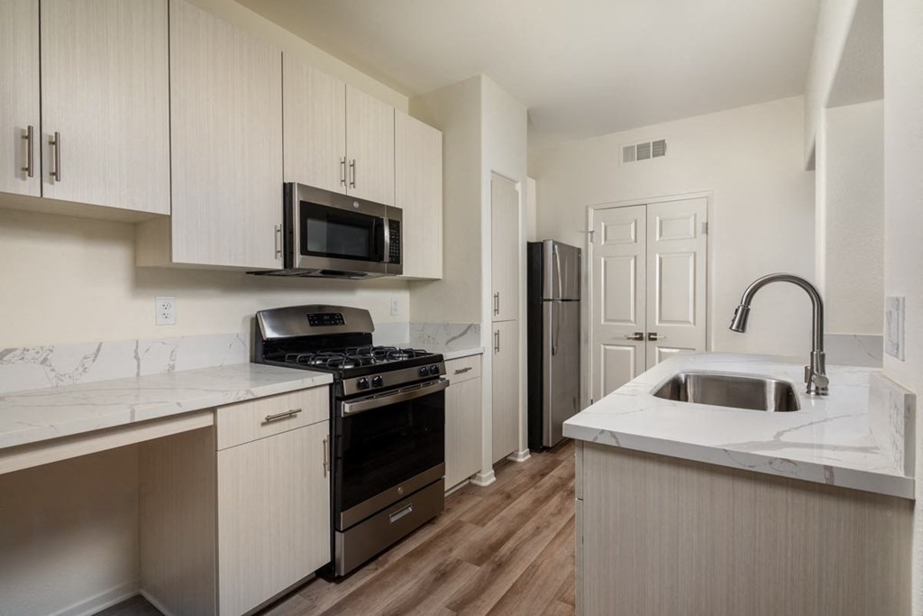 Kitchen with a wood floor and white cabinets at Casoleil, CA, 92154
