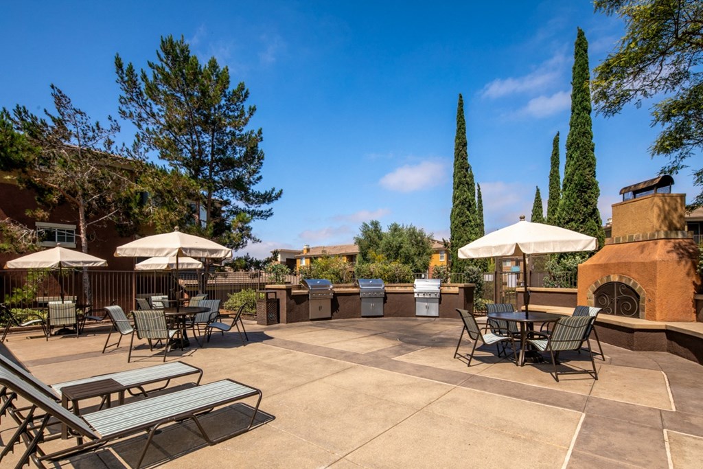 Patio with tables and chairs and umbrellas at Casoleil, San Diego, CA, 92154