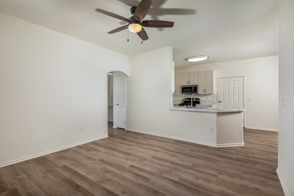 Empty living room with a ceiling fan and a kitchen at Casoleil, San Diego, CA