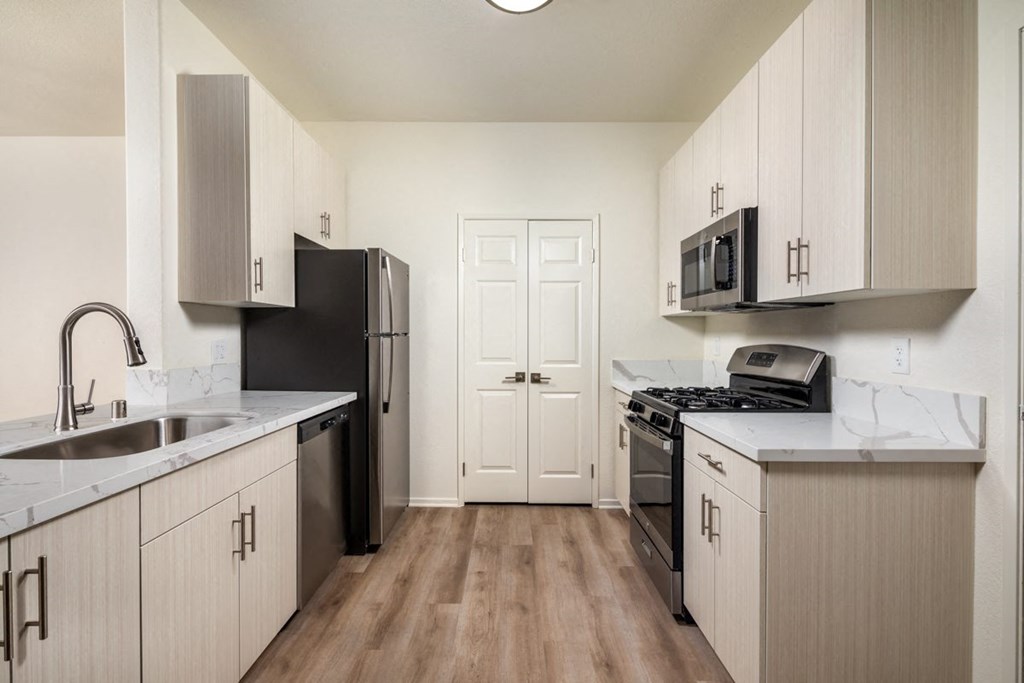 Kitchen with stainless steel appliances and white cabinets at Casoleil, San Diego, CA, 92154