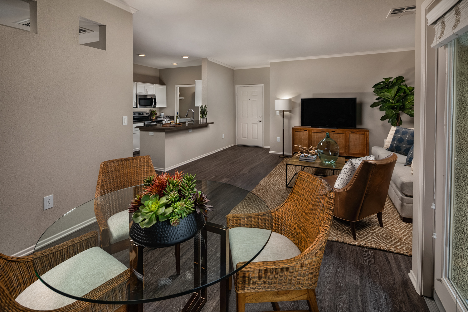 A modern living room with a glass table and chairs.