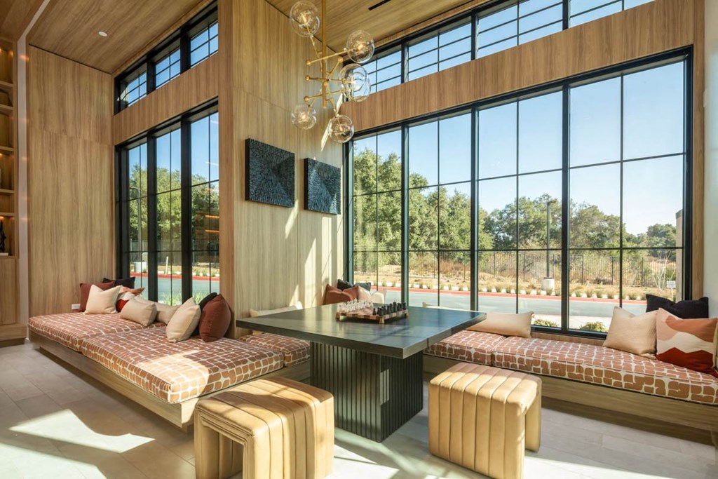 A modern living room with a large window and a wooden ceiling.