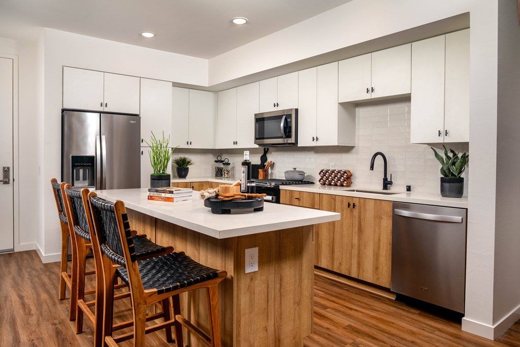 A kitchen with white and wood cabinets at The Croft apartments for rent in Wildomar, CA.