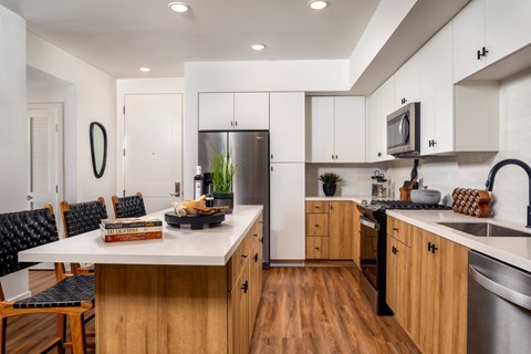 A modern kitchen with wooden cabinets and a white island.
