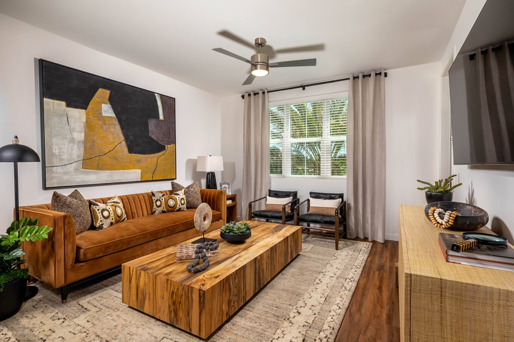 A living room with a brown couch, a coffee table, and a painting on the wall.