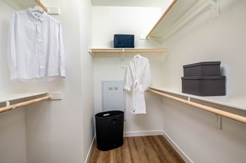 A white shirt is hanging on a hanger in a white closet.