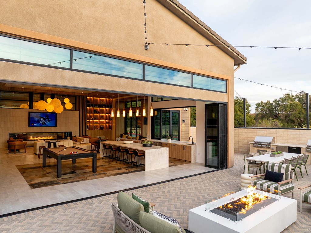 A modern outdoor patio with a fire pit and seating area.