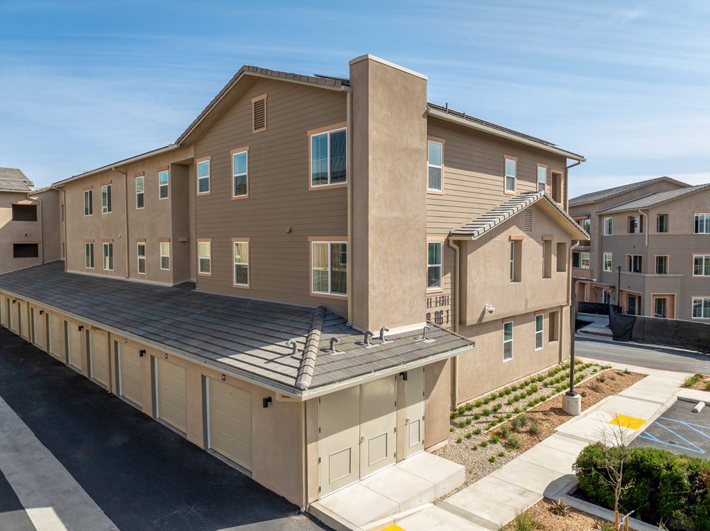 A modern apartment complex with a mix of beige and brown exterior colors.