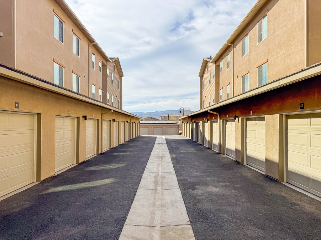 A long, narrow driveway separates two rows of garages.