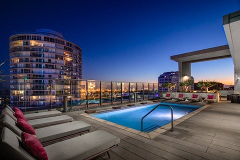 a pool on the rooftop of an apartment building at night