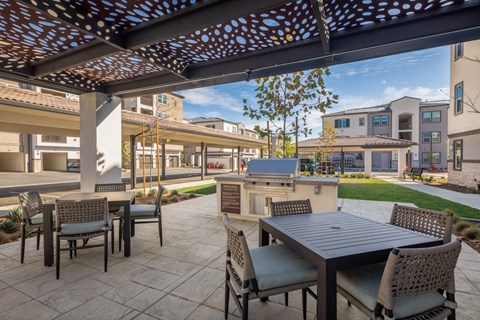 A patio with a table and chairs under a pergola.