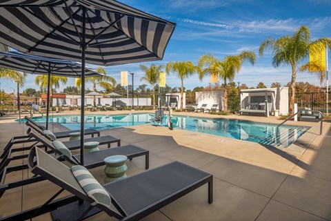 A poolside area with sun loungers and umbrellas.