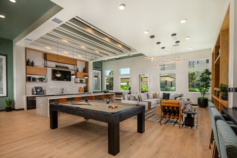 an open living room with a pool table and a kitchen