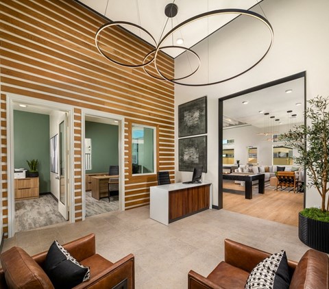 a living room with leather furniture and a large chandelier