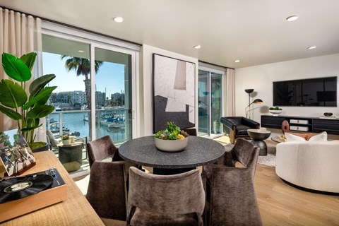 A modern dining room with a table set for six and a view of the city.
