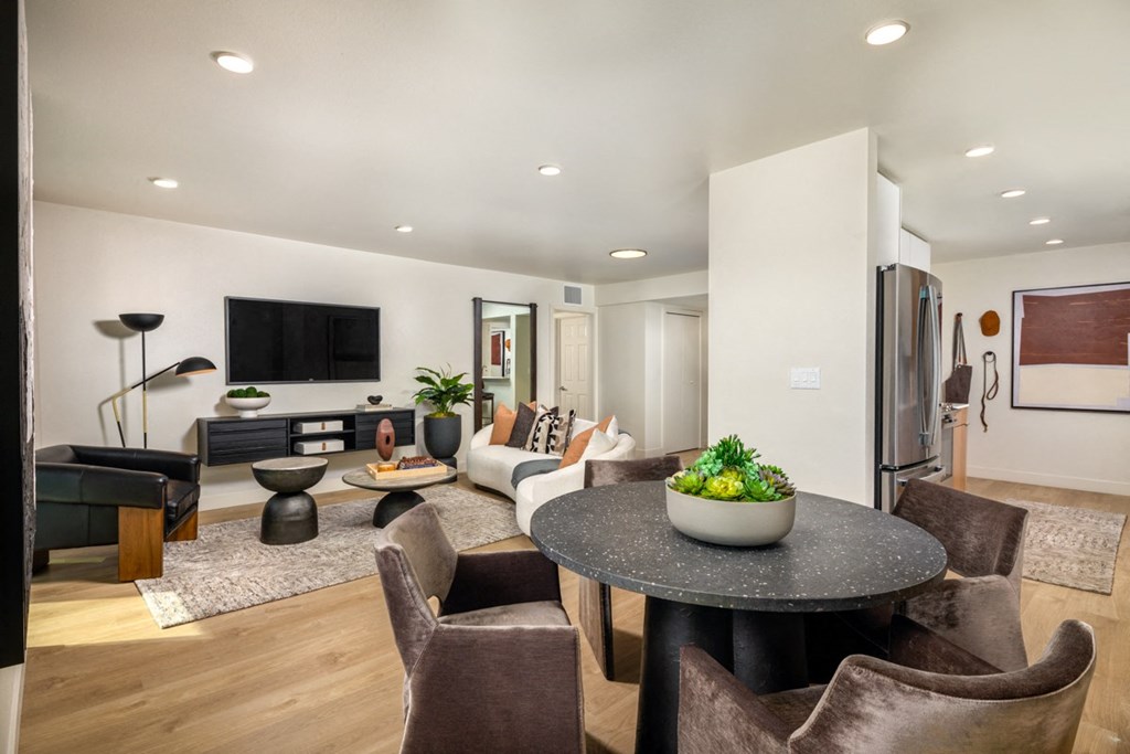 A modern living room with a black table and brown chairs.
