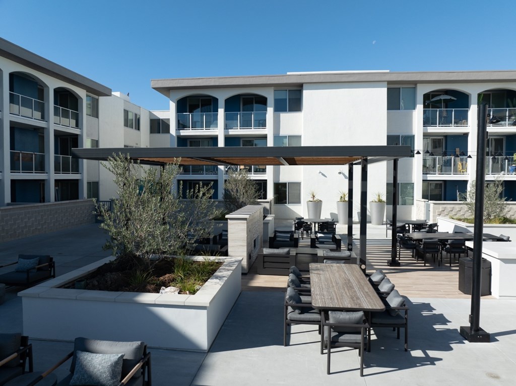 A patio with a table and chairs is in front of a building.