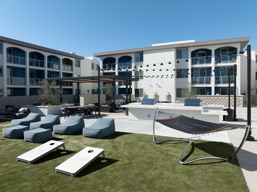 A modern building with a white facade and a black and white striped hammock.