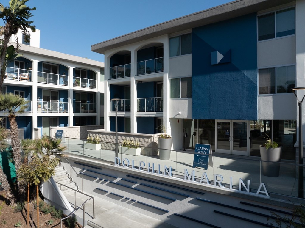 Dolphin Marina is a leasing office for a building with multiple balconies and a clear blue sky in the background.